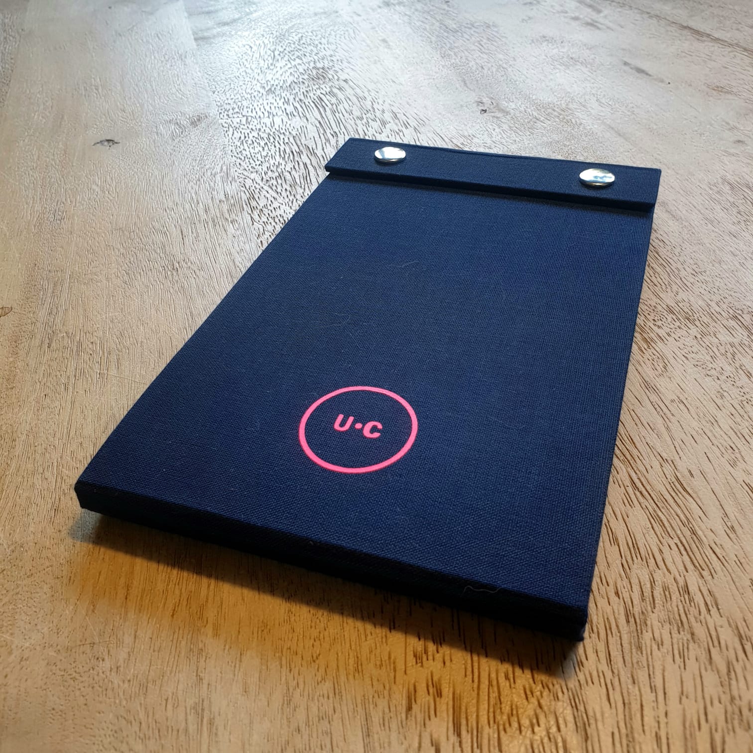 gepersonaliseerd-notitieboek-logo-undercover-neon-op-blauw-linnen